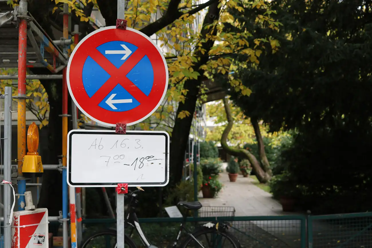 Halteverbotsschild mit Zeitangabe in städtischer Allee