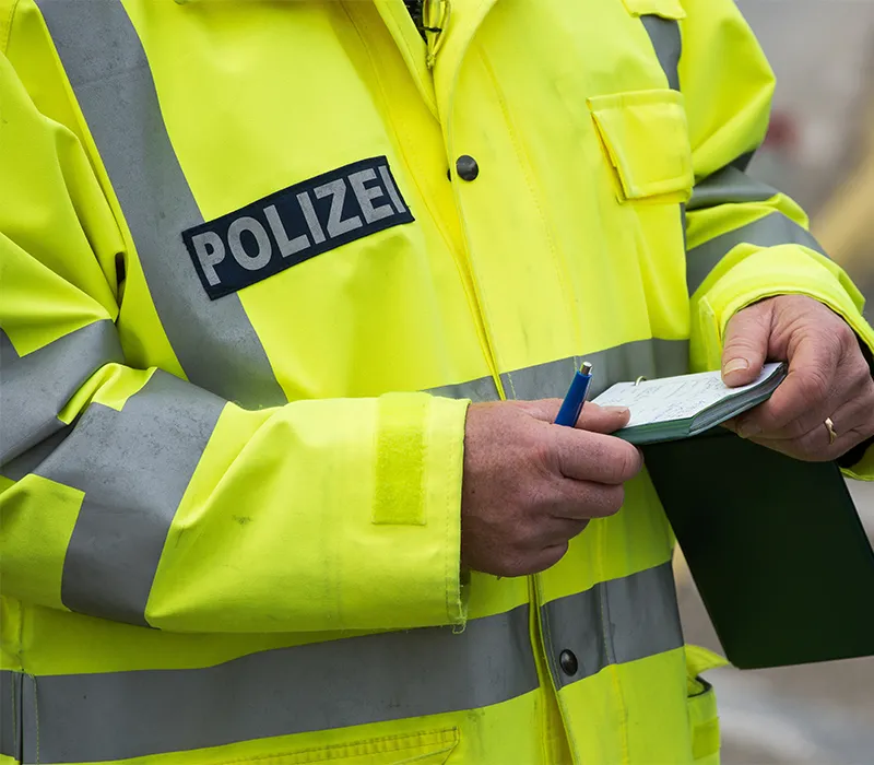 Polizist beim schreiben eines Strafzettel fürs Falschparken