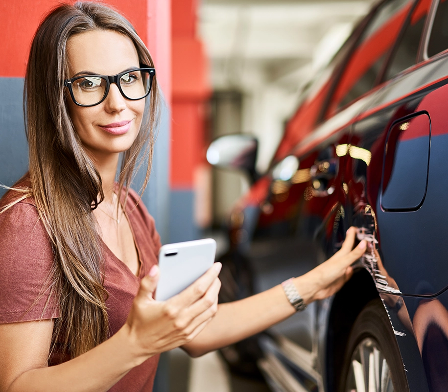 Eine Frau hält ein Handy in der Hand und berührt das Autos