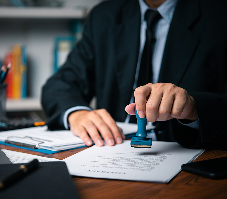 Eine Person stempelt ein Dokumente im Büro